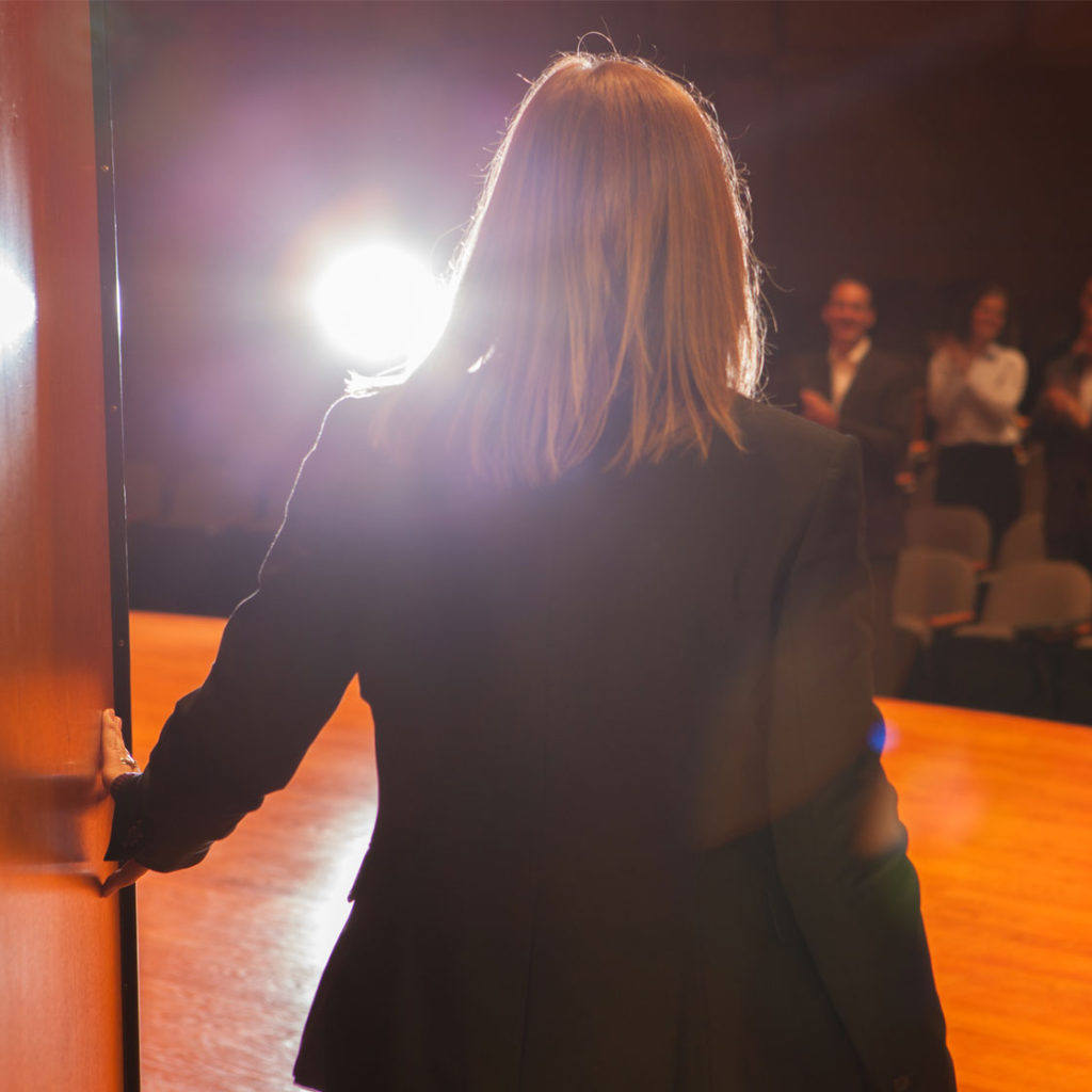 A woman standing in front of a light.