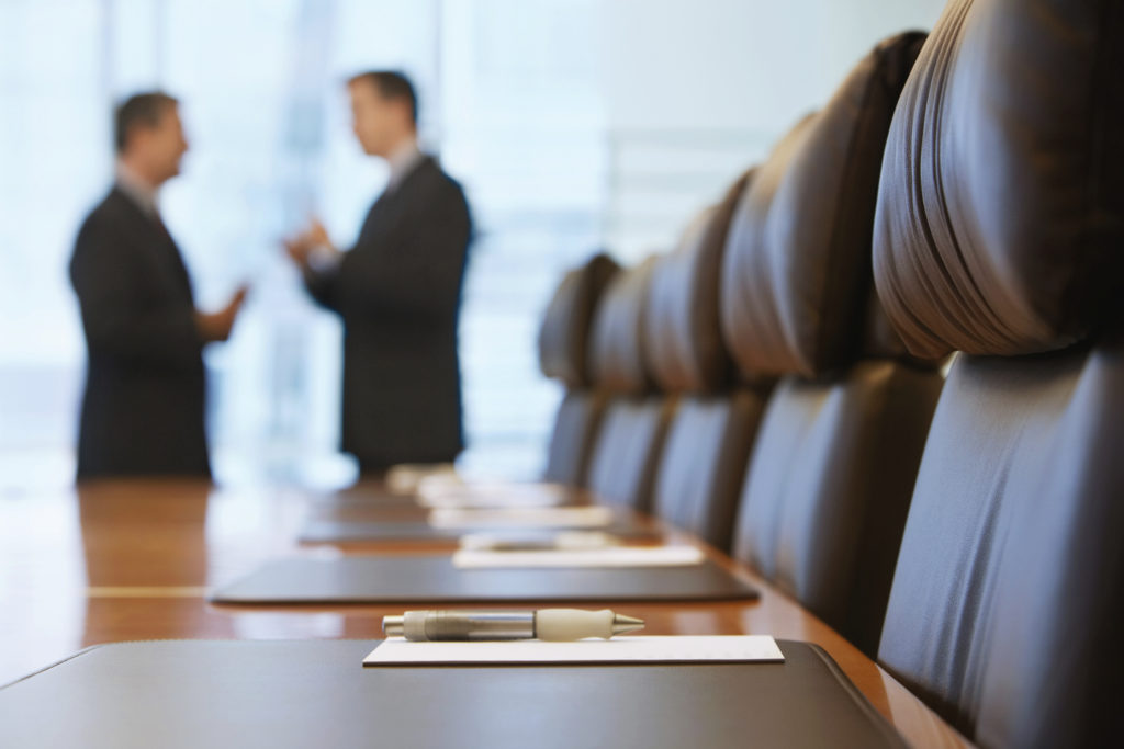 A conference room with two people in the background.