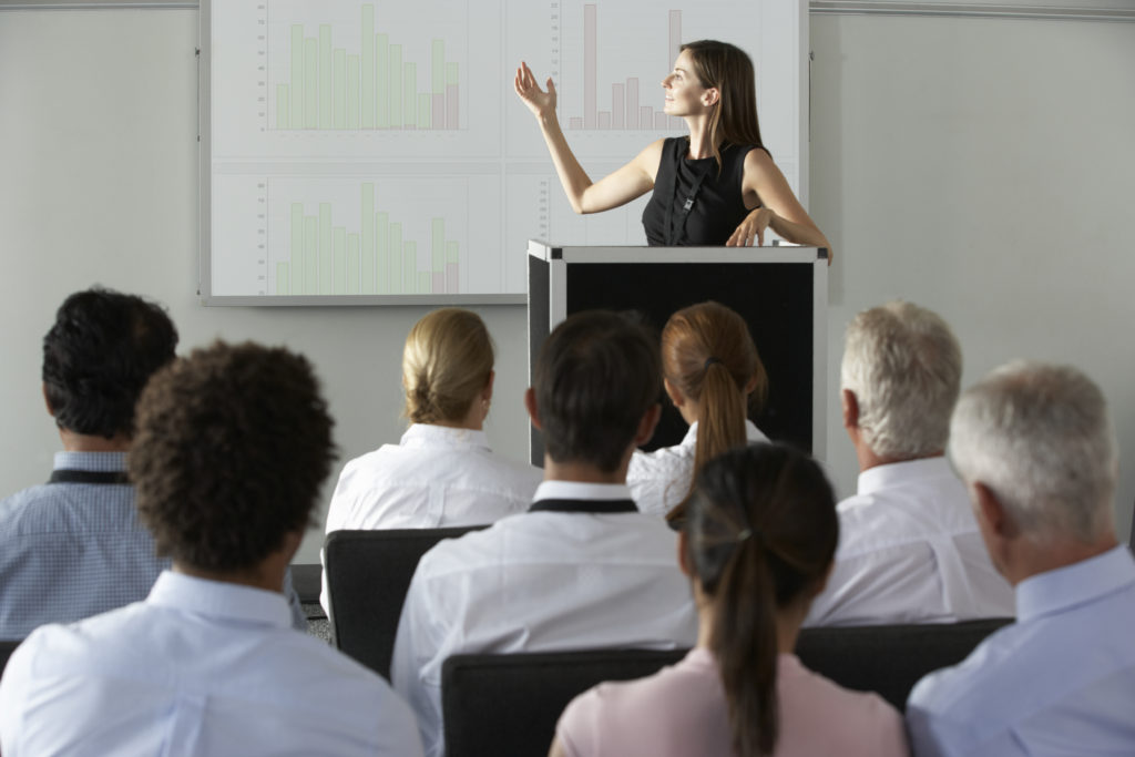 A woman is giving a presentation to an audience.