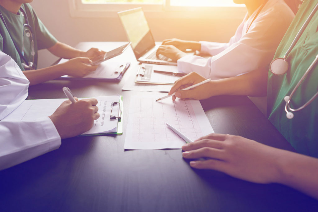 A group of people sitting at a table with papers.