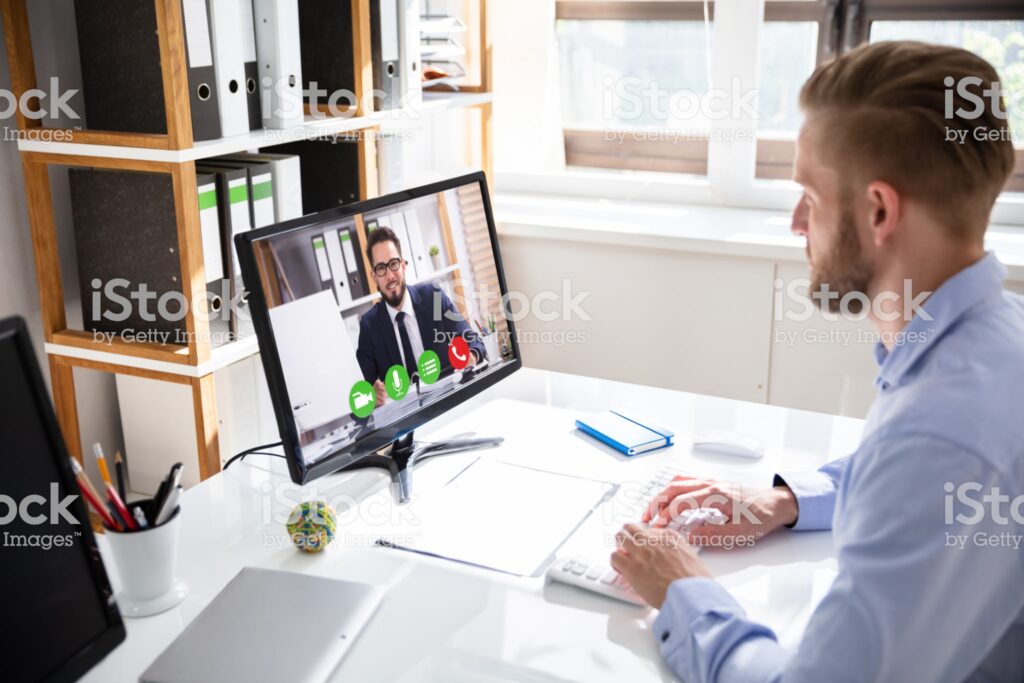 A man sitting at his desk in front of a computer.