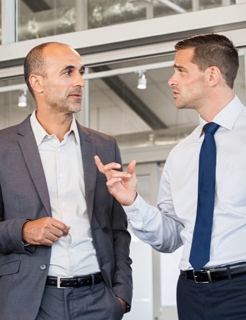 Two men in suits talking to each other.